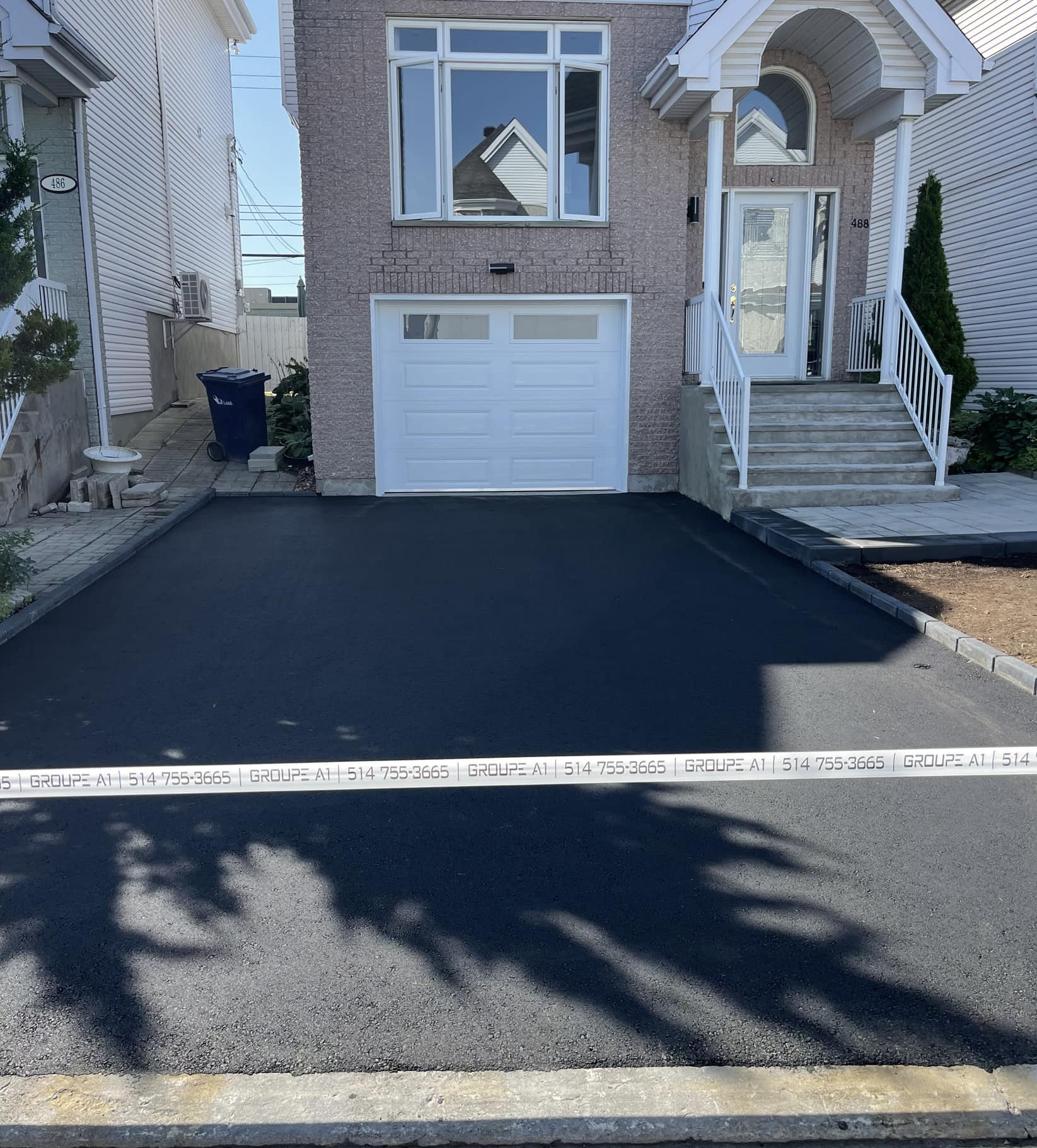 Residential asphalt driveway in front of a garage